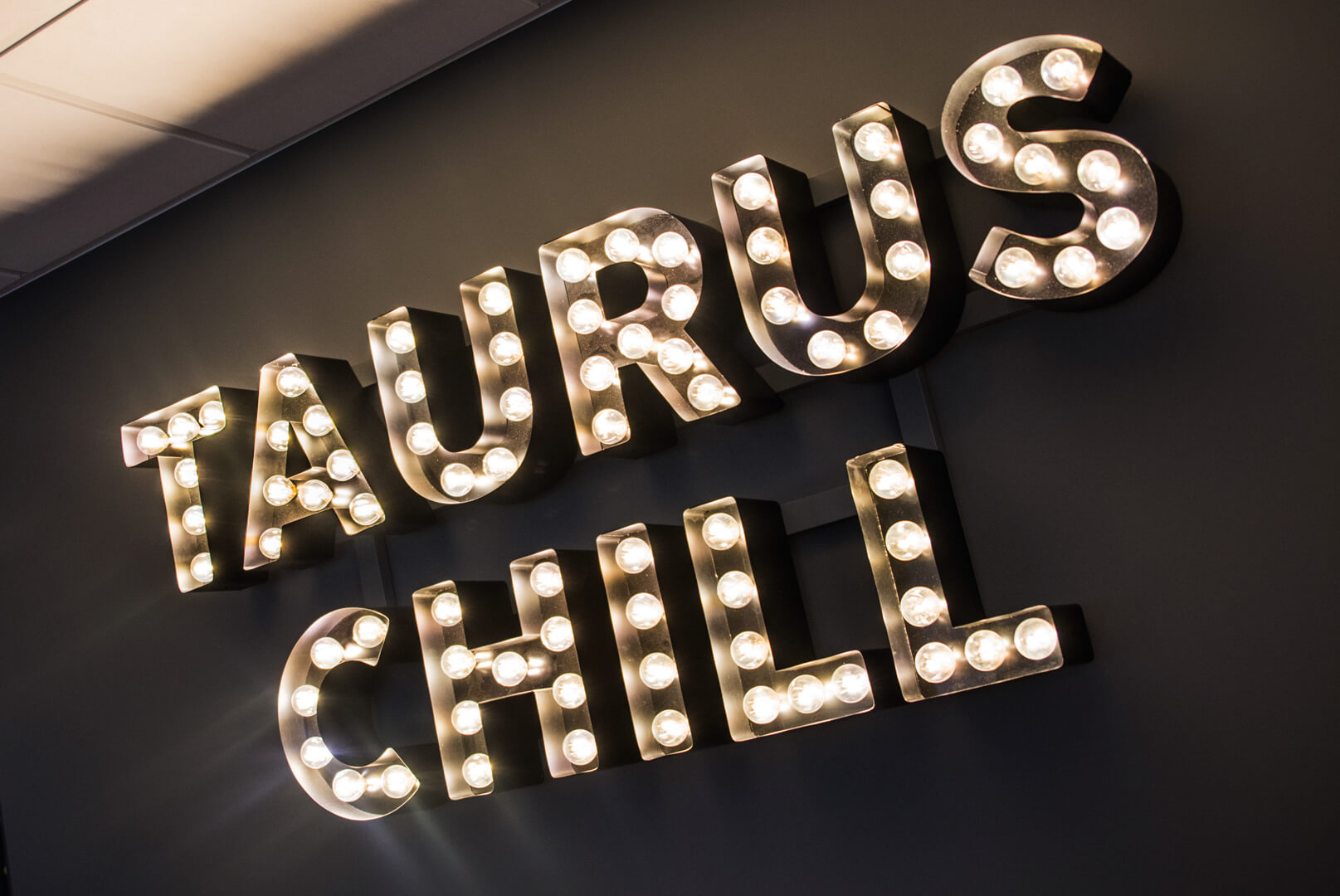 Taurus Chill - letters with light bulbs placed on the wall